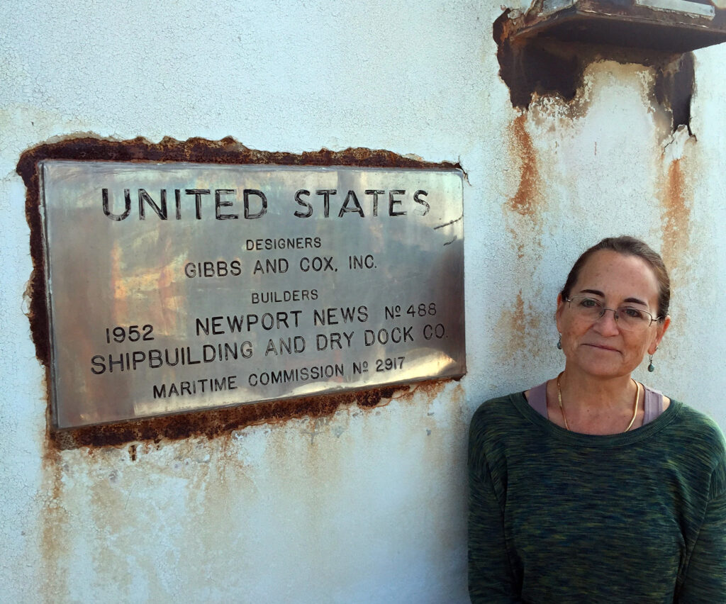 a woman standing next to a sign