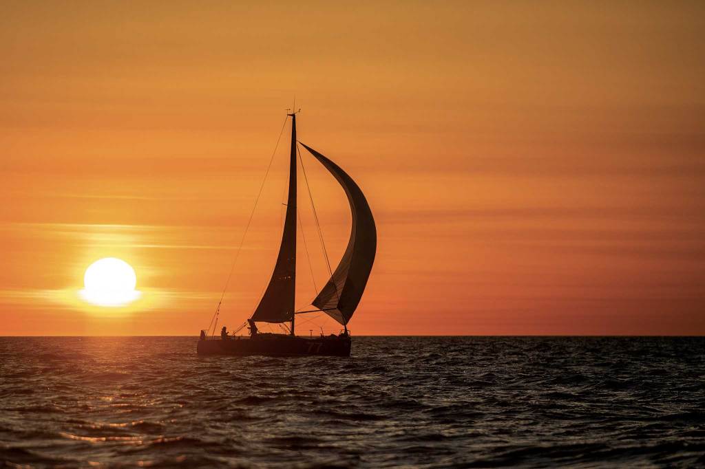 A silhouette of a sailboat at sunrise