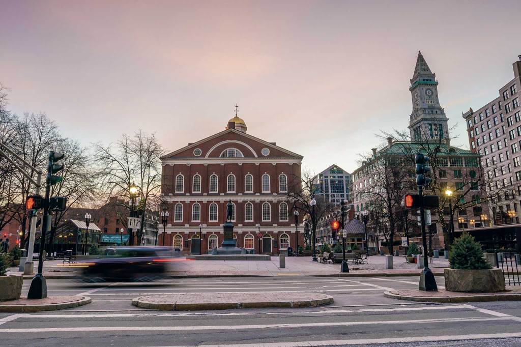 View of a brick building with a statue in front of it. Quincy Marketplace