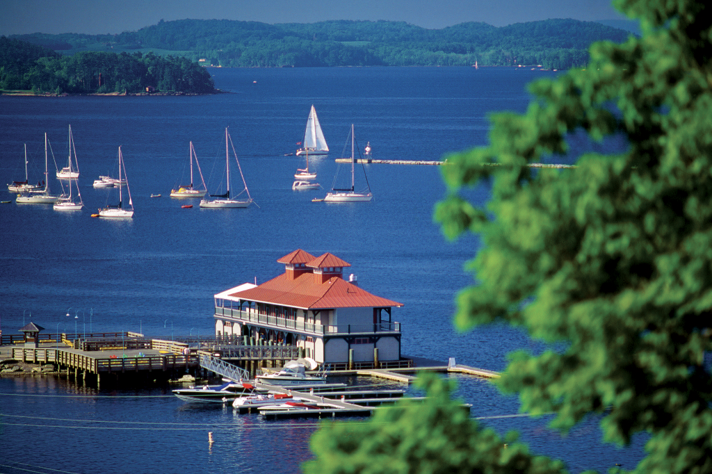 A bright sunny day with a view of boats on the water behind a yacht club