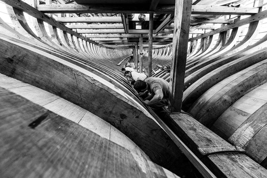 Black and white photograph of men building a boat