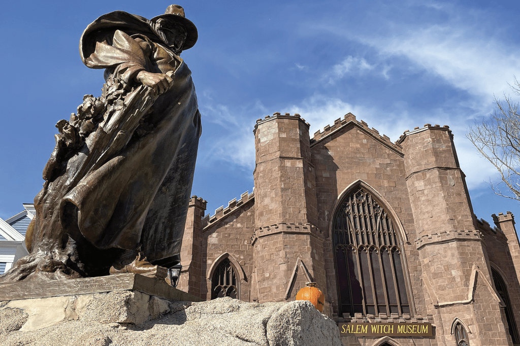 A photo of a bronz statue with a large brich building in the background