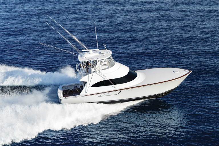 A white motor boat racing across the water leaving a wake.