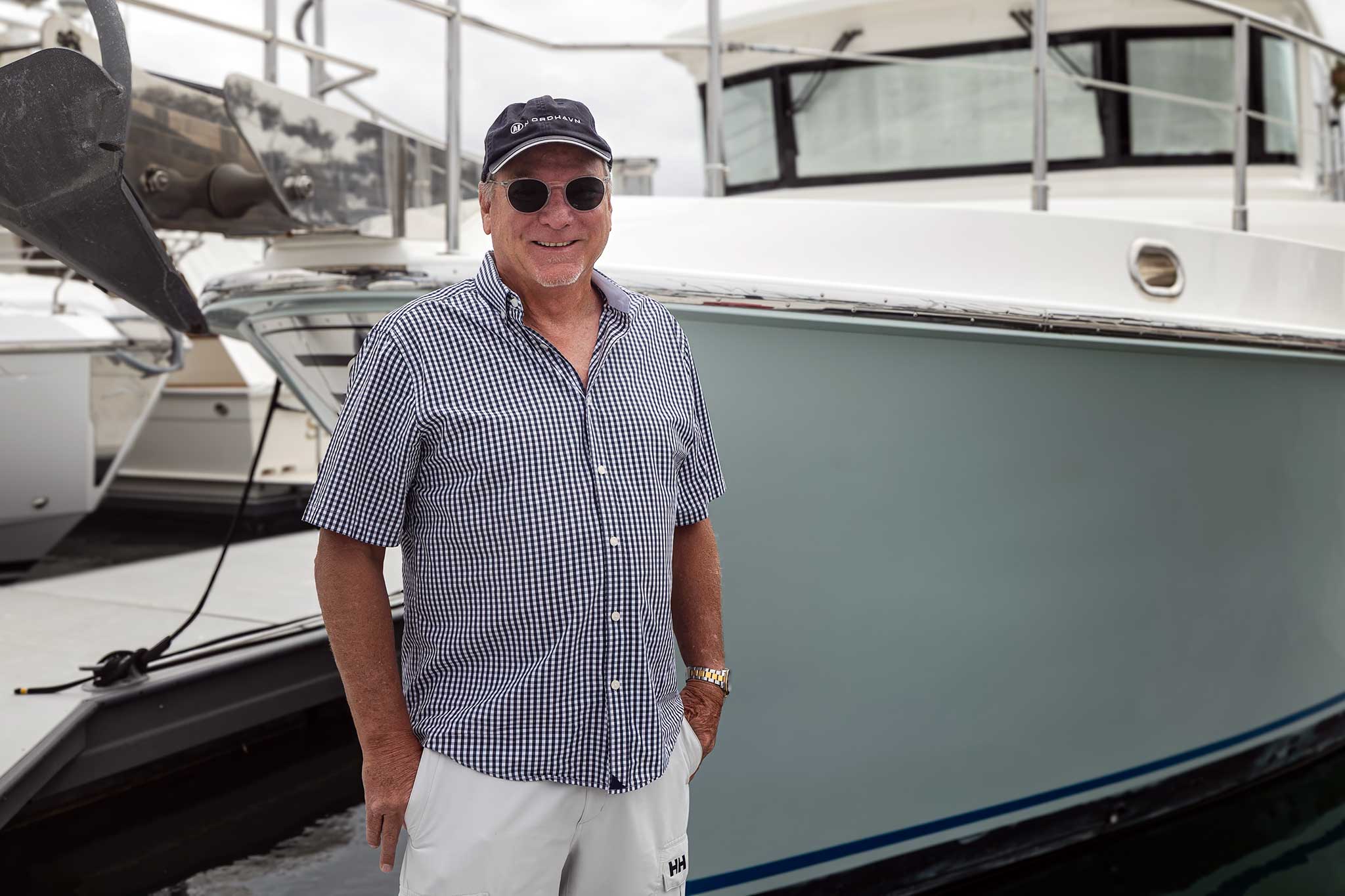 A man smiling (as he should) in front of a boat.