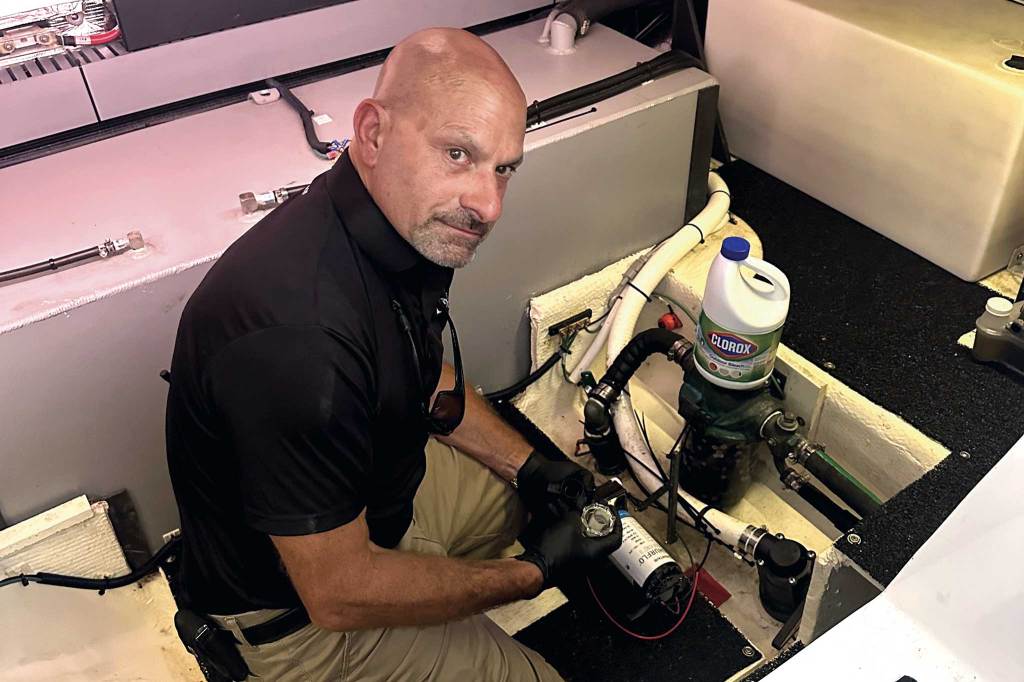Freshwater-systems-2609 Bob Petzold, president of Petzold’s Marine Center, sanitizes a freshwater tank and plumbing by flushing with a mix of chlorine and water. courtesy Bob Petzold